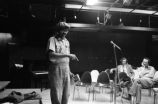 Etheridge Knight: Oxford, Miss. Knight performing at microphone in front of small audience (EKP 3-79-12/11 #296)