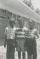 Three young boys standing outside a school in Camden, Alabama.