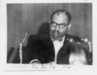 Mississippi State Sovereignty Commission photograph of Dr. T. R. M. Howard dressed in a bowtie and sitting behind three microphones, Chicago, Illinois, 1950s