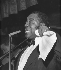 Louis Armstrong [singing at microphone, holding handkerchief [black-and-white photoprint, black-and-white]