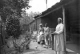 Three African American women with quilts outside a cabin in rural Wilcox County, Alabama.