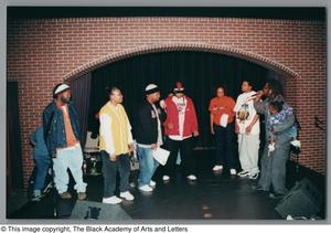 Photograph of a group of performers standing on a stage