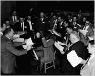 Company executives sing-along, with African-American keyboard player. Coca-Cola Company party at the Capitol City Club, Atlanta, Georgia, March 18, 1954