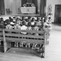 Children kneeling in pews in the chapel at Nazareth Catholic Mission in Montgomery, Alabama.