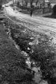 Man walking on a muddy street.