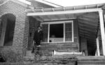 African American man standing on house porch