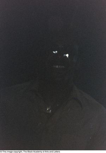 Underexposed photograph of an individual wearing sunglasses