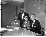 Carrie J. Ellis seated with three men