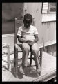 Young boy sits on hand-woven chair