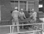 Employees operating a tractor track pin punch at the Ray-Brooks Machinery Company at 2275 West Fairview Avenue in Montgomery, Alabama.