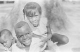 Michael and Gerald Dabney with their cousin, Dannice Simon, sitting in front of a tree during a cookout in the Madison Park community in Montgomery, Alabama.