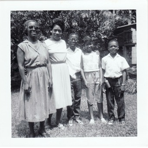 Inez Irving Hunter poses with a woman and her children in a back yard