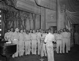 African American servicemen singing on stage during a recording of the "Sgt. Gene Autry" radio program at the municipal auditorium in Birmingham, Alabama.