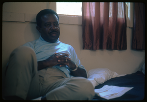 Rev. Ralph Abernathy seated on a hotel room bed