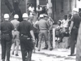 Onlookers watch as police confront man after riot, Rochester, NY, 1964