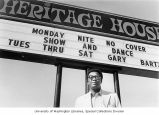 Gary Bartz standing in front of the Heritage House jazz club sign on Empire Way S., Seattle, Washington, June 10, 1974