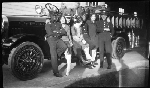 Three firemen and three women leaning against Oakland Fire Department fire truck