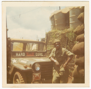 Photograph of an American soldier leaning on a jeep in Vietnam