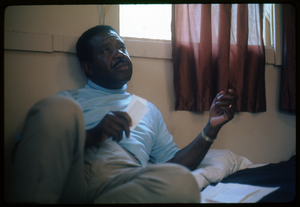 Rev. Ralph Abernathy seated on a hotel room bed