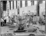 Workers craft Konti statues inside the Education building