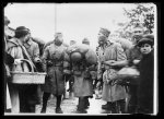 Negro troops from Alabama pause in their March to get a handful of refreshments from the Red Cross canteen workers, Miss O.C. MacDonald and Miss Janet Hunter of Montgomery, Ala., who had arrived in Europe only a few days before. The photograph is taken from the running board of the car, in which Henry P. Davison, Chairman of the War Council of the American Red Cross was travelling on a tour of inspection of Southern England. Mr. Davison talked with the two young women about their work and himself, sampled the Red Cross chocolate. Photograph taken near Winchester, England