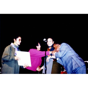 Mario Bauza (right) kissing the hand of Jovita Fontanez on stage at the Jorge Hernandez Cultural Center.