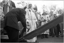 Man pouring lighter fluid on a banner during a Ku Klux Klan rally in Montgomery, Alabama.