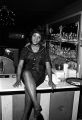 Waitress at the Laicos Club in Montgomery, Alabama, seated on the counter at the bar.