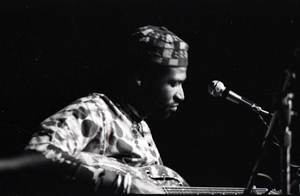 Taj Mahal in concert at Northfield, Mass.: Taj Mahal seated, playing steel guitar