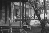 Woman sitting on a rocking chair on the front porch.