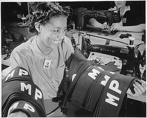 "Insignia for military police are being turned out in an eastern quartermaster corps depot where this young worker has obtained war production employment."