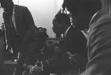 Martin Luther King, Jr., seated and speaking to a young man during a meeting at Maggie Street Baptist Church in Montgomery, Alabama.