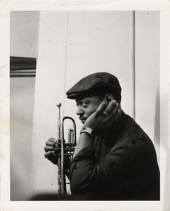 Ellington band member holding a trumpet : black-and-white photoprint.