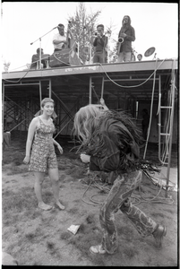 May Day concert and demonstrations: couple dancing below concert stage while Charles Mingus performs