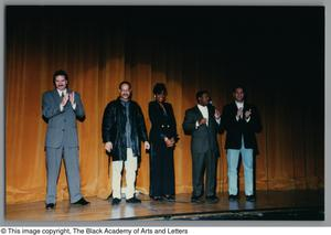 Left-angled low angle of five people standing on a stage