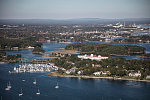 An October 2017 aerial view of New Castle, New Hampshire, with the historic seaport of Portsmouth, the largest city along the shortest coastline (18 miles) of any U.S. state, in the distance. The large white building with a red roof is the 1874 Wentworth-by-the-Sea Hotel, a historic grand resort hotel in New Castle. Now managed by Marriott, it is one of a handful of the state's surviving Gilded Age grand hotels, and the last located on the seacoast