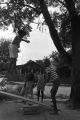 Diane Foster and Elizabeth Ellis playing on a make-shift seesaw in the dirt yard in front of a brick house in Newtown, a neighborhood in Montgomery, Alabama.