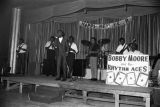 Bobby Moore and the Rhythm Aces performing on stage at the Laicos Club in Montgomery, Alabama, during a New Year's celebration.