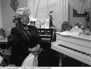 Francine Morrison seated at her pianos posing for her picture