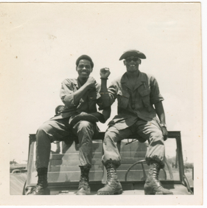 Photograph of two American soldiers sitting on a jeep in Vietnam