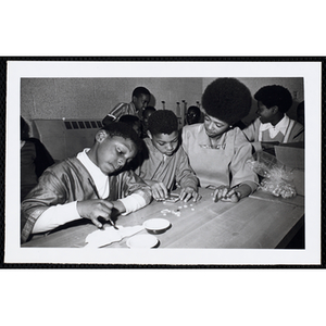 An art instructor and two boys working on their projects at the Roxbury Boys' Club