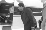 Hosea Williams holding a briefcase and looking inside the door of a plane at the airport in Montgomery, Alabama.