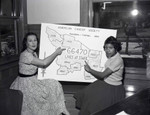 Young women hold American Cancer Society area map