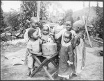 Children looking at a charity box in the shape of an African boy, Tanzania, ca. 1900-1914