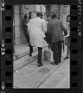 People outside Boston University administration building with a television