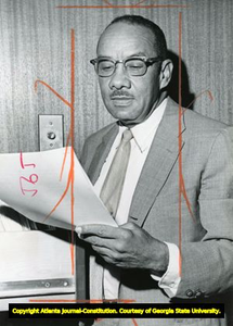 Portrait photo of Dr. Harry V. Richardson, reading a document from a file cabinet, Atlanta, Georgia, August 29, 1968.