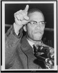 [Malcolm X, head-and-shoulders portrait, facing right, gesturing with right hand, during Harlem rally]