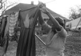 Mrs. Rosa Lee Turner hanging laundry on a clothesline in the dirt yard behind her house in Montgomery, Alabama.