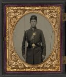 [Isaac Yost of Company C, 118th Regiment Illinois Infantry, standing in uniform with bayoneted musket and revolver]