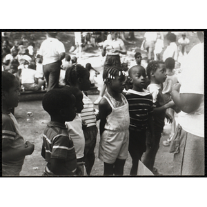 A Group of children standing and waiting with a camp counselor